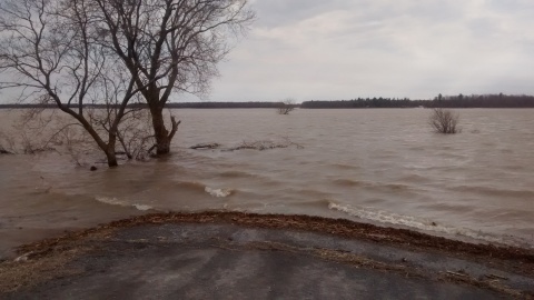 floodwaters over road, with little waves breaking